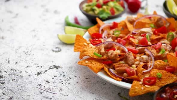 A Plate of Delicious Tortilla Nachos with Melted Cheese Sauce, Grilled Chicken