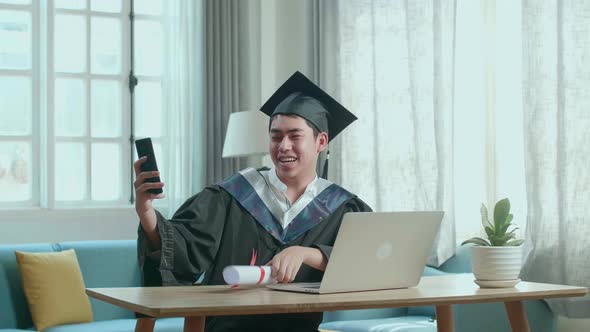 Excited Man Showing Off A University Certificate To The Family During An Online Video Call At Home