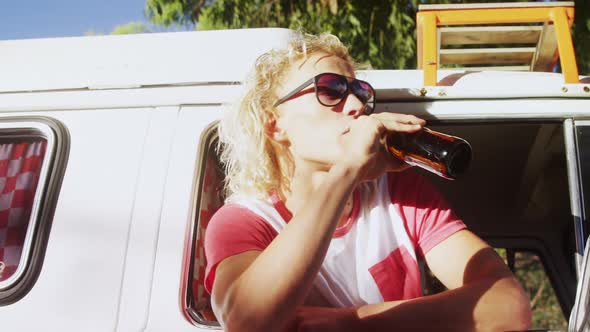 Man sitting in van and drinking beer 4k