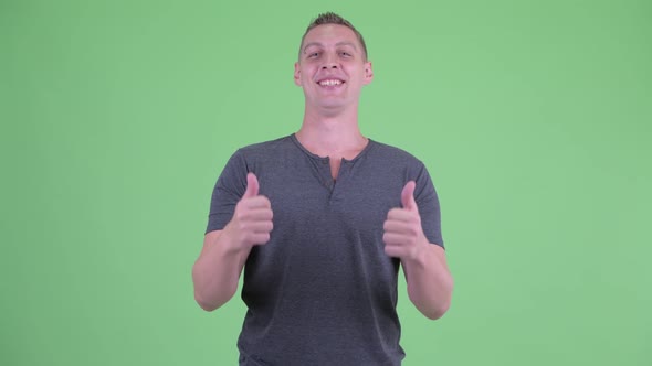 Portrait of Happy Young Man Giving Thumbs Up and Looking Excited