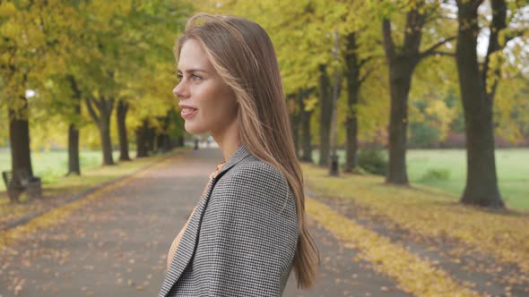 Confident Caucasian Brunette Girl Looking Around and Walking Away Along the Road