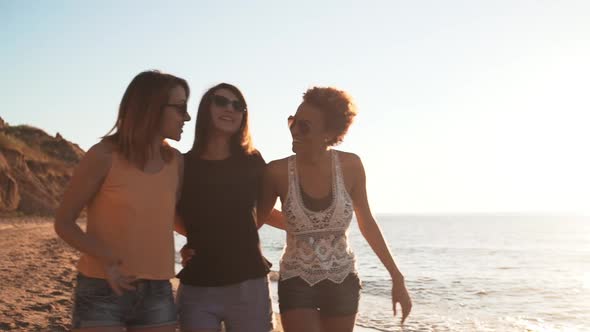 Friends Smiling Laughing Speaking Walking at Seaside at Sunrise