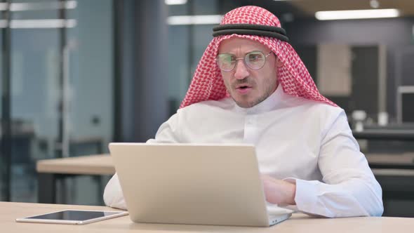 Middle Aged Arab Man with Laptop having Loss, Failure