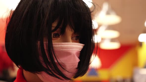 Mannequin with Short Black Wig and Pink Mask Stands in Store