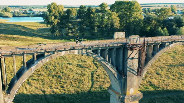 A Man Is Doing a Sports Run Along an Ancient Bridge