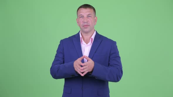 Mature Macho Businessman in Suit Explaining Something