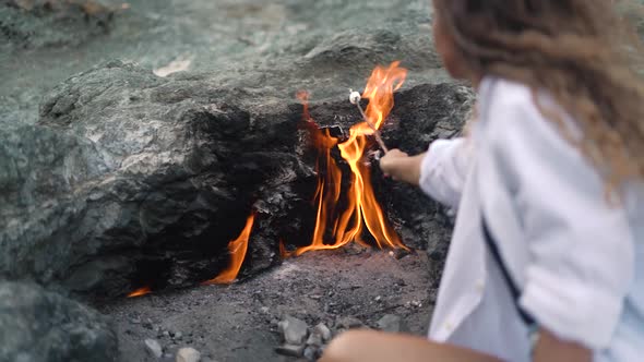 Slim Woman Roasts Marshmallows Over Chimaera Mountain Fire