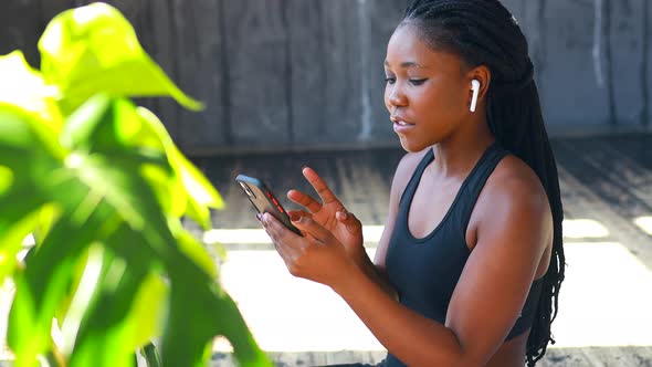 Hispanic Woman with Afro Pigtails Hair Listening a Music By Wireless Ear Pods Wear Sporty Clothes