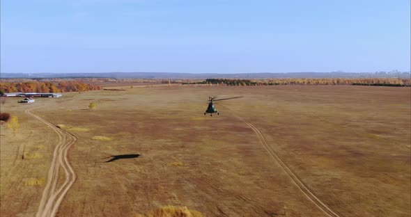 Helicopter Flies Over the Field and Village Houses