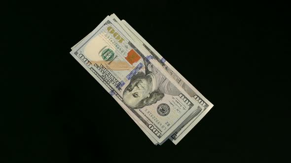 Stack of Hundred Dollar Bills Falling on Table
