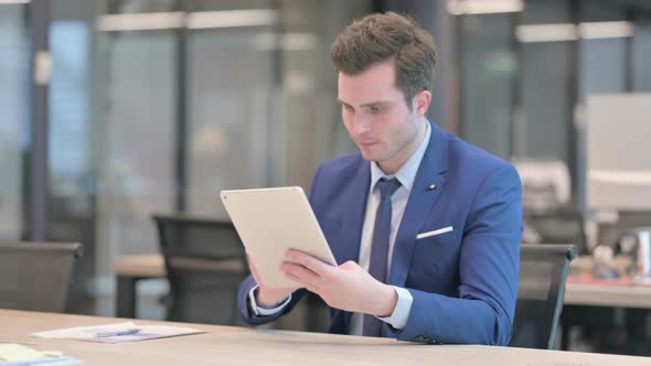 Businessman Reacting to Loss on Tablet in Office