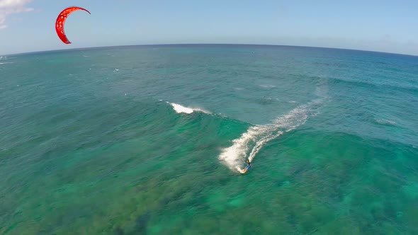 Aerial view of a man kitesurfing in Hawaii.