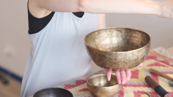 Woman Playing on Tibetan Singing Bowl While Sitting on Yoga Mat