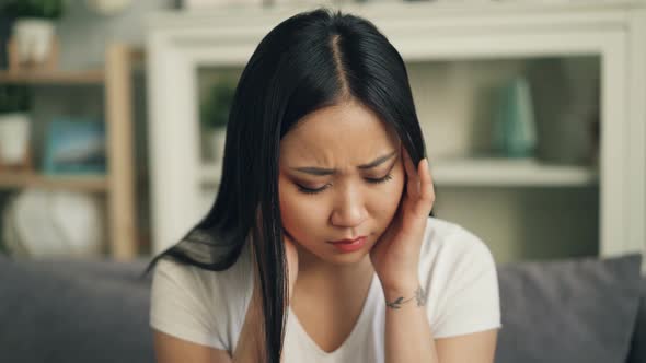 Attractive Asian Woman Is Suffering From Strong Headache Touching Her Head Massaging Temples Sitting