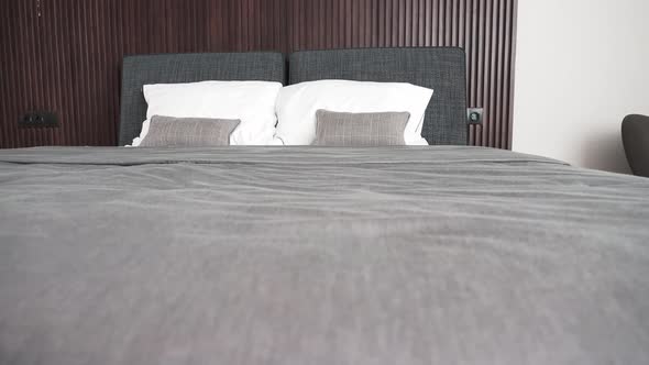 Modern double bed made up with clean white pillows and grey blanket