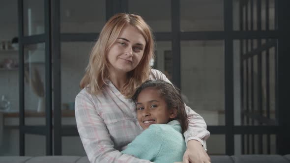Caring Mom with Mixed Race Child in Love Embrace