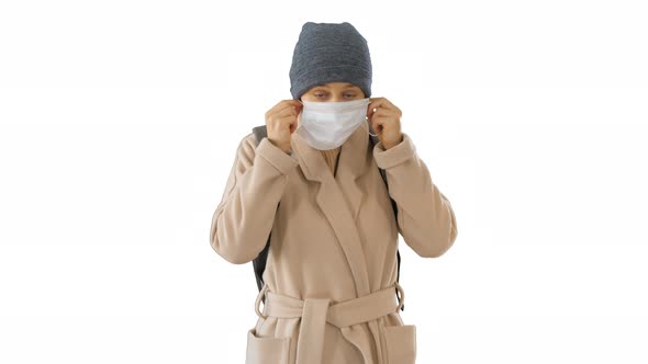 Blonde Woman Walking and Putting Face Protection on in Prevention for Coronavirus Covid 19 on White