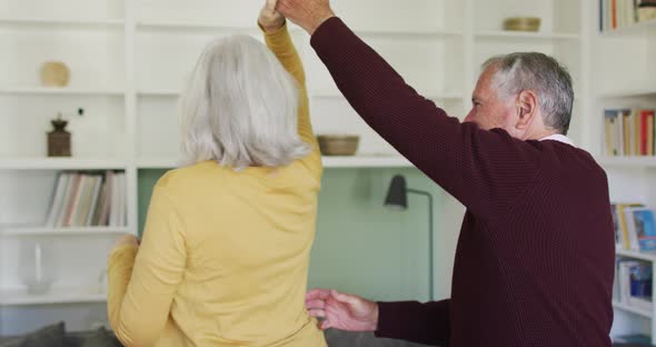 Happy senior caucasian couple embracing and slow dancing togther