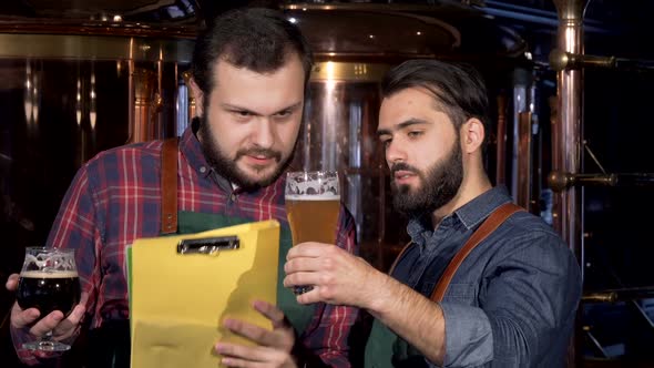 Two Male Brewers Examining Delicious Craft Beer They Manufacture Together