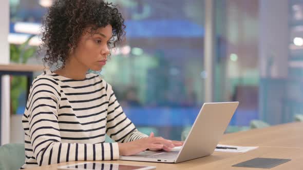 African Woman Working on Laptop in Office