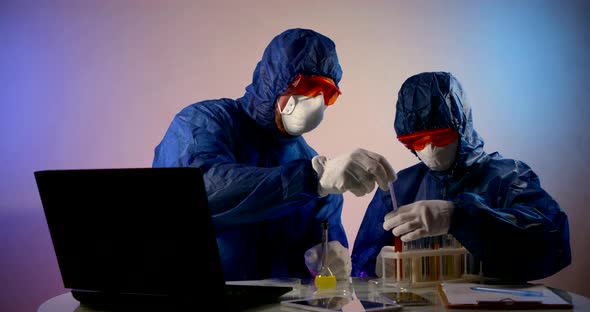 Scientists in the Lab Check Samples for Infection with Bacteria or a Virus. Protective Clothing