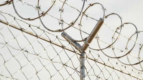 Endless view at the top of prison or airport fence on blue sky background. 4k HD