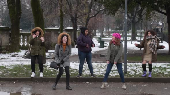 slow motion five young women multiethnic outdoor snow field having fun dancing