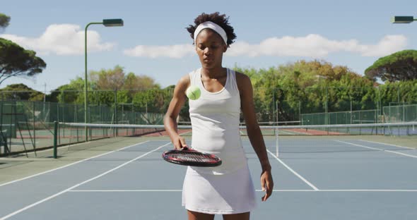 Video of african american female tennis player holding racket and bouncing ball