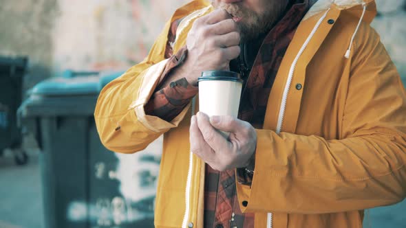 Carton Coffee Cup in the Hands of a Homeless Man