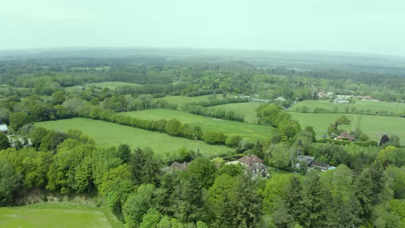 Aerial view over green patchwork farmland countryside pasture landscape