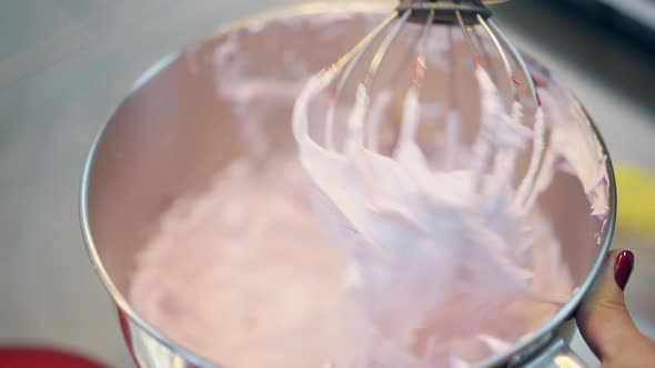 Woman Demonstrates Pink Thick Cake Cream in Metal Bowl