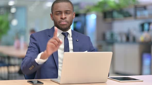 African Businessman with Laptop Showing No Sign in Office