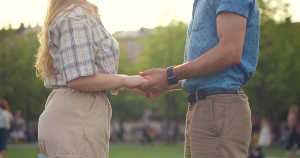 Cropped Shot of Young Caucasian Couple Holding Hands in Summer Park