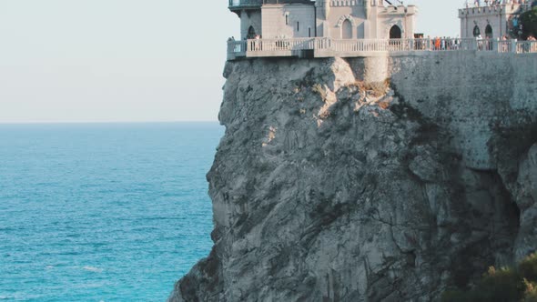 Sea Landmark  a Modern Castle on a Cliff and People Visiting It