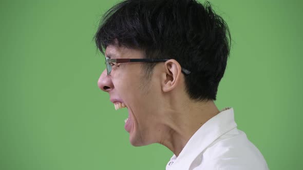 Profile View of Angry Young Asian Businessman Screaming