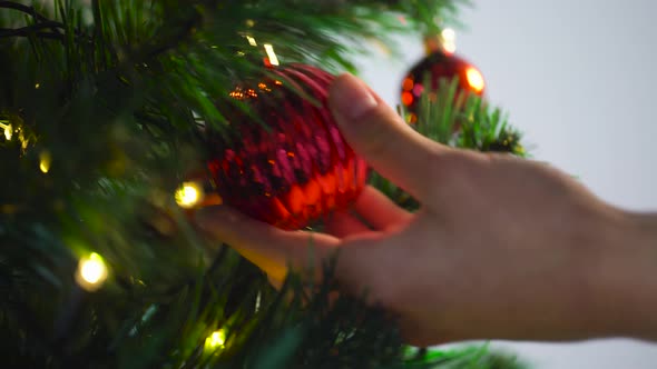 Hand Decorating Christmas Tree with Ball 