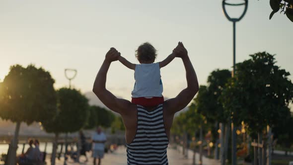 Father and Son Walking in City at Sunset