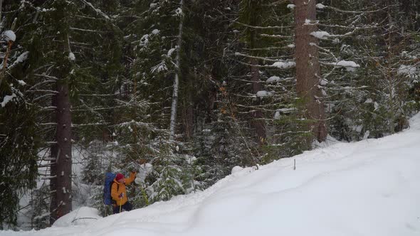 Backpacker Hiking in Winter Forest