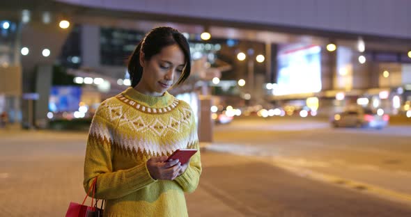 Woman use of mobile phone in city at night