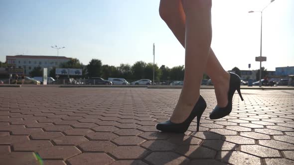 Female Legs in High Heels Shoes Walking in the Urban Street. Feet of Young Business Woman in High