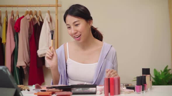 Beauty blogger present beauty cosmetics sitting in front camera for recording video Asian woman.