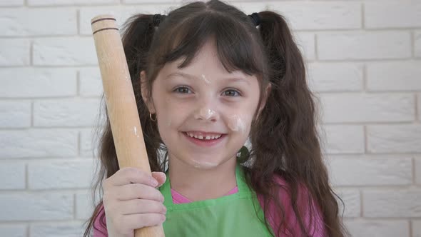 Child in the kitchen with a rolling pin