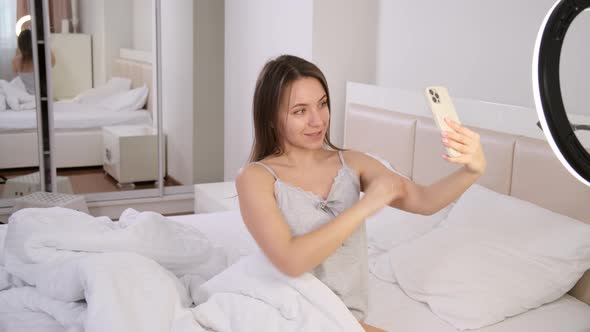 Blogger Recording Vlog Video on Smartphone at Home in Bed