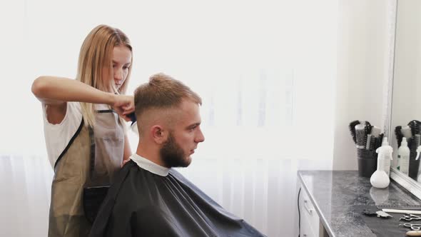 Stylist Doing Hair Styling with Spray in Beauty Salon