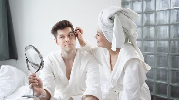 Portrait of Funny Couple Doing Makeup at Home