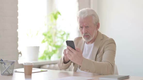 Upset Old Man Reacting to Loss on Smartphone