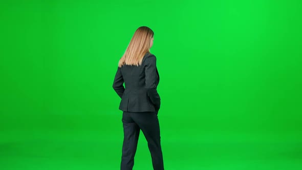 Businesswoman in a Suit Walking Down the Street on a Green Background a Passerby on a Walk Chroma