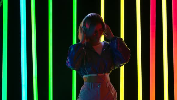 Portrait of a Young Stylish Woman in Sunglasses Dancing To the Music with Big White Headphones and