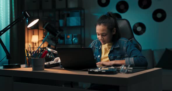 Girl Studies Diligently in Front of Laptop Notes with Pencil in Notebook Rewrites Reads Ebook Remote