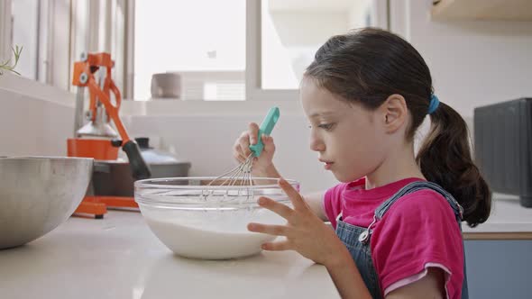 Kids preparing and mixing ingredients for pancakes in the kitchen